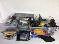 Overall view of assorted tools and hardware in plastic bins and boxes, including screws, nails, sockets, hand tools, bungee cords, and more.