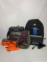 Full lot of travel bags, containers, cooler, and mug including Titan cooler, MEC crossbody bag, OGIO backpack, Stanley mug, and wet/dry bag