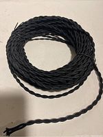 Full coil of black twisted speaker cable, showing thickness and twist pattern of the cable.