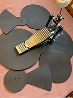 View showing all six black practice pads and the bass drum pedal with white felt beater, arranged on a pink cloth surface.