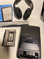 Lot with Sony cassette player, Panasonic cassette recorder, Sennheiser headphones, digital scanner and Amazon Kindle device