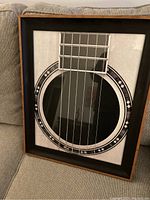 Front view of framed guitar print showing close-up of guitar sound hole and strings.