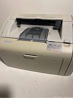 Front angled view showing paper output tray, control buttons, and HP LaserJet 1018 label.