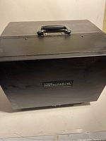 Closed view of the black hard carrying case with handle and 'Singer Kodak Instaload XL' label