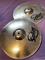 Pair of Solar by Sabian hi-hat cymbals with visible logos and traditional finish.