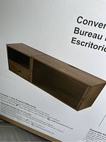 Photo of the boxed wall cabinet desk showing the front view with an open shelf, drawer, and fold-down desk surface.