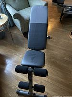 Front view of Wieder exercise bench showing padded backrest and seat with foam leg rollers.