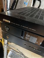 Close-up photo of front left side of black Yamaha AV receiver showing brand name Yamaha, model HTR-5840, power button, and headphone jack.