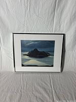 Front view of a framed Lawren Harris Pic Island print with black frame and white matting.