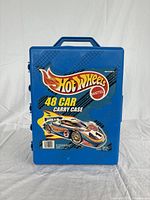 Front view of blue Hot Wheels branded 48 car carry case with flame graphics and model car image