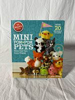 Front of kit box showing colorful mini pom-pom pet animals and kit branding