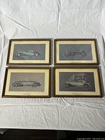 Set of four vintage framed Alexis Sakhnoffsky car prints laid out on white cloth background.