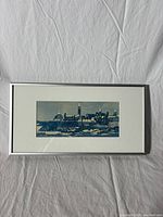 Full view of the framed screenprint artwork on a white fabric background, showing the entire piece including the silver frame and white mat.