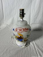 Photo showing the lamp side with design of two dwarfs and 'Snow White and the Seven Dwarfs' text.