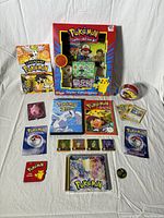 Full assortment arranged together showing books, cards, DVD, collector tin, and badge