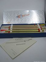 Set of FASTURN fabric tube turning system tubes laid out inside original box with instruction manual visible in front