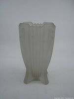 Front view of a frosted glass Art Deco vase with vertical ribbing and stepped top, showing overall shape and color.