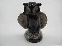 Front view of ceramic owl figurine with glossy black and gray finish showing shape and markings.