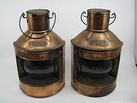 Front view of the pair of metal candle holders marked 'Port' and 'Starboard' with glass panels and wire handles.