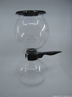 Full view of vintage Bodum Pebo coffee maker showing its two glass chambers with black plastic lid and handle