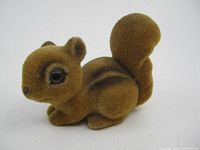 Side angle of brown fuzzy flocked chipmunk showing profile and tail detail.