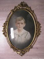 Full view of the oval metal framed drawing showing the boy and frame details