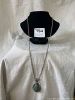 Full view of the sterling silver necklace displayed on a black bust against white cloth.