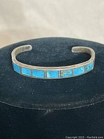 Front view of sterling silver cuff bracelet showing seven rectangular turquoise inlays mounted side-by-side along the front outer band.