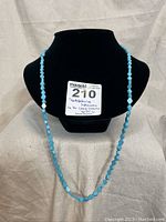 Turquoise hexagon bead necklace displayed on black bust with MaxSold tag