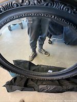 Full view of the round mirror leaning on a surface showing the ornate frame and reflective glass.