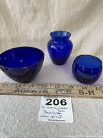Set of three cobalt blue glass pieces displayed with measuring ruler, showing size reference.