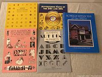 Five books laid out showing various titles related to design and advertising from 1920s/30s.