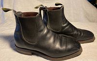 Side view of black leather ankle boots showing elastic panel and leather condition