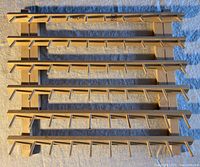 Front view of the wooden thread holder organizer showing five rows with multiple pegs and June Tailor branding in the center.