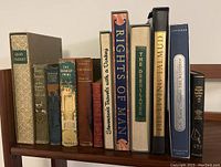 Books lined up on a shelf showing titles and condition, highlighting various vintage and antique books including 'Quo Vadis?', 'Boy Scouts', 'Driven From Home', and 'The Bobbsey Twins'