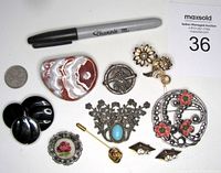 Lot of 10 vintage Mid Century Modern brooches and pins including a ceramic pin, black plastic pins, needlepoint pin, and metal floral pins.