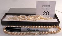 Two pearl necklaces displayed with a Sharpie marker for scale. Triple strand freshwater pearls in a box, single strand pearls outside box.