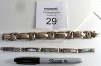 Photo of two sterling silver bracelets, one chunky link style, one with rectangular mother of pearl inset panels. A Sharpie pen is placed below for scale.