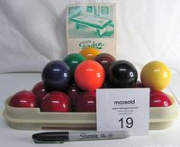 Photo showing the billiard balls stacked with a Gendron Canada booklet and a Sharpie pen for scale, highlighting the glossy finish and size of the balls.