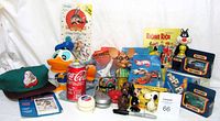 Wide view of entire toy lot showing various vintage and new toys including Donald Duck puppet, Bugs Bunny Ertl car set, Matchbox trucks, hat, Topo Gigio figure, and sports cards.