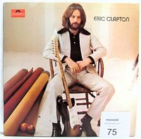 Front cover of the Eric Clapton self titled vinyl LP album, showing Eric Clapton seated with guitar.