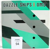 Front view of the Dazzle Ships vinyl LP cover showing original die cut sleeve with geometric design and color scheme of teal, gray, and white with black accents.