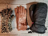 Three pairs of gloves laid flat showing leopard print gloves, brown leather gloves, and black quilted mittens.