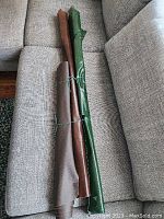 Three rolled leather hides tied with string, showing length and shape laid on gray upholstery.