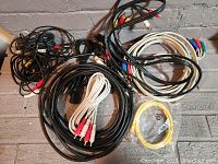 All cables coiled and mixed, including RCA and component cables with some white cables and a yellow patch cable
