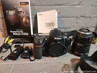 All components arranged: camera body, lens, charger, remote, cable, strap, manuals, book