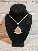 Front view of the silver Christmas tree pendant necklace displayed on a black necklace bust showing the tree shape and star detail.