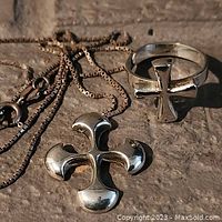 Silver cross pendant necklace with box chain and matching ring showing cross design.