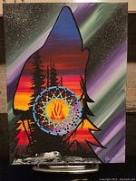 Front view of the original painting featuring wolf head silhouette filled with sunset colors and forest details with a circular flame motif in the center.