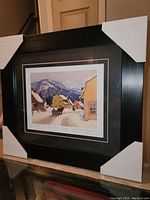 Framed print with protective white corner guards showing overall framed piece.